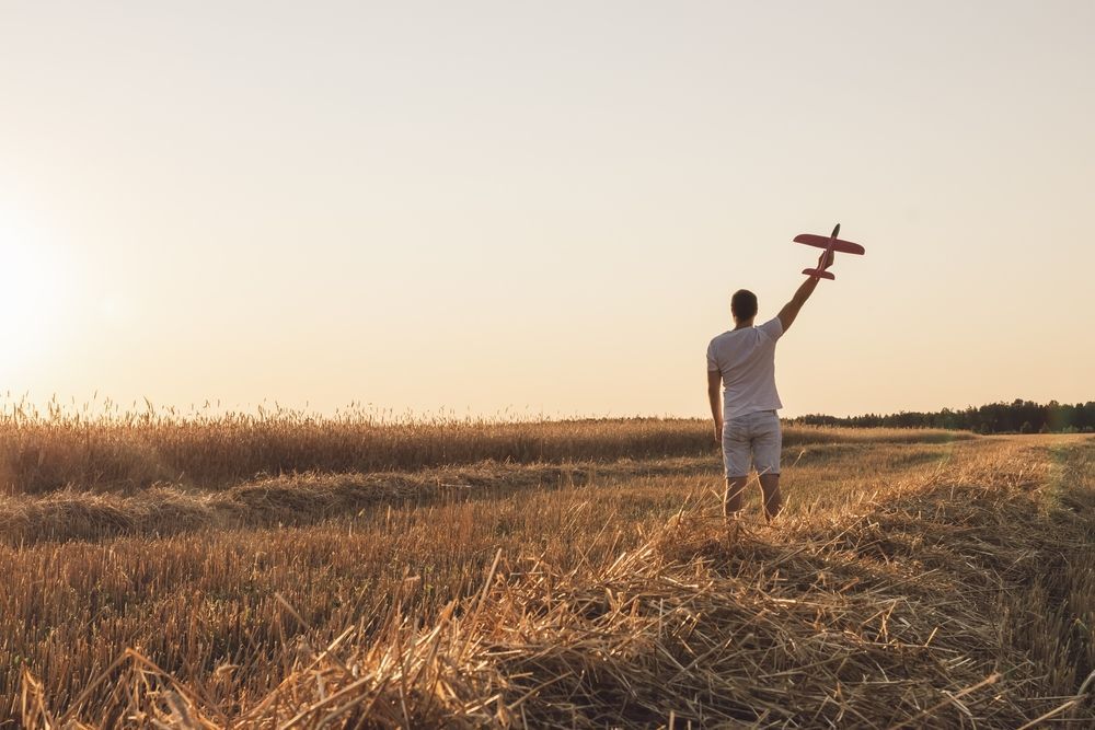 Человек держит самолётик